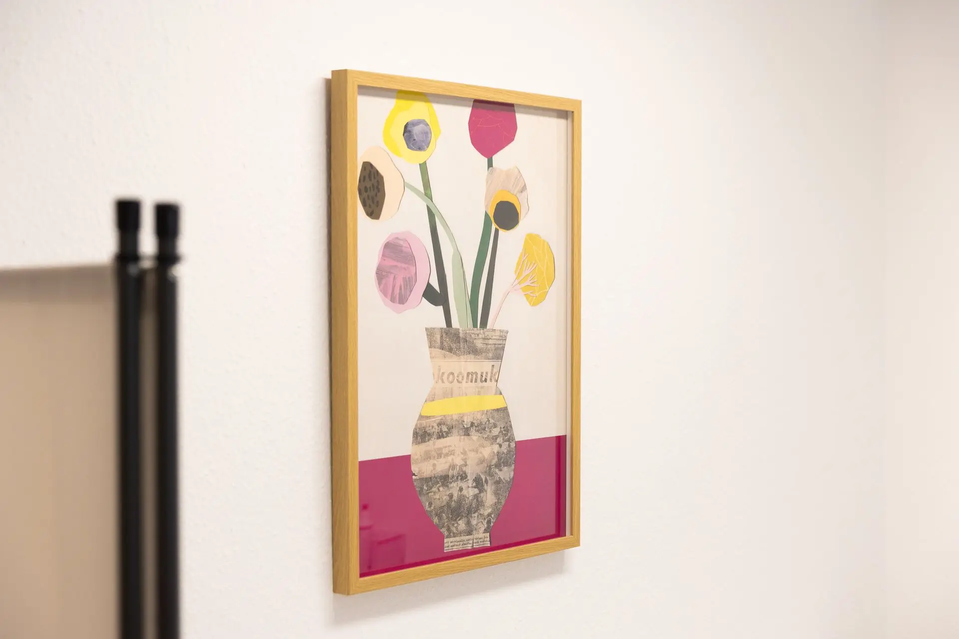 Gerahmtes Kunstwerk mit bunten Blumen an einer weißen Praxiswand