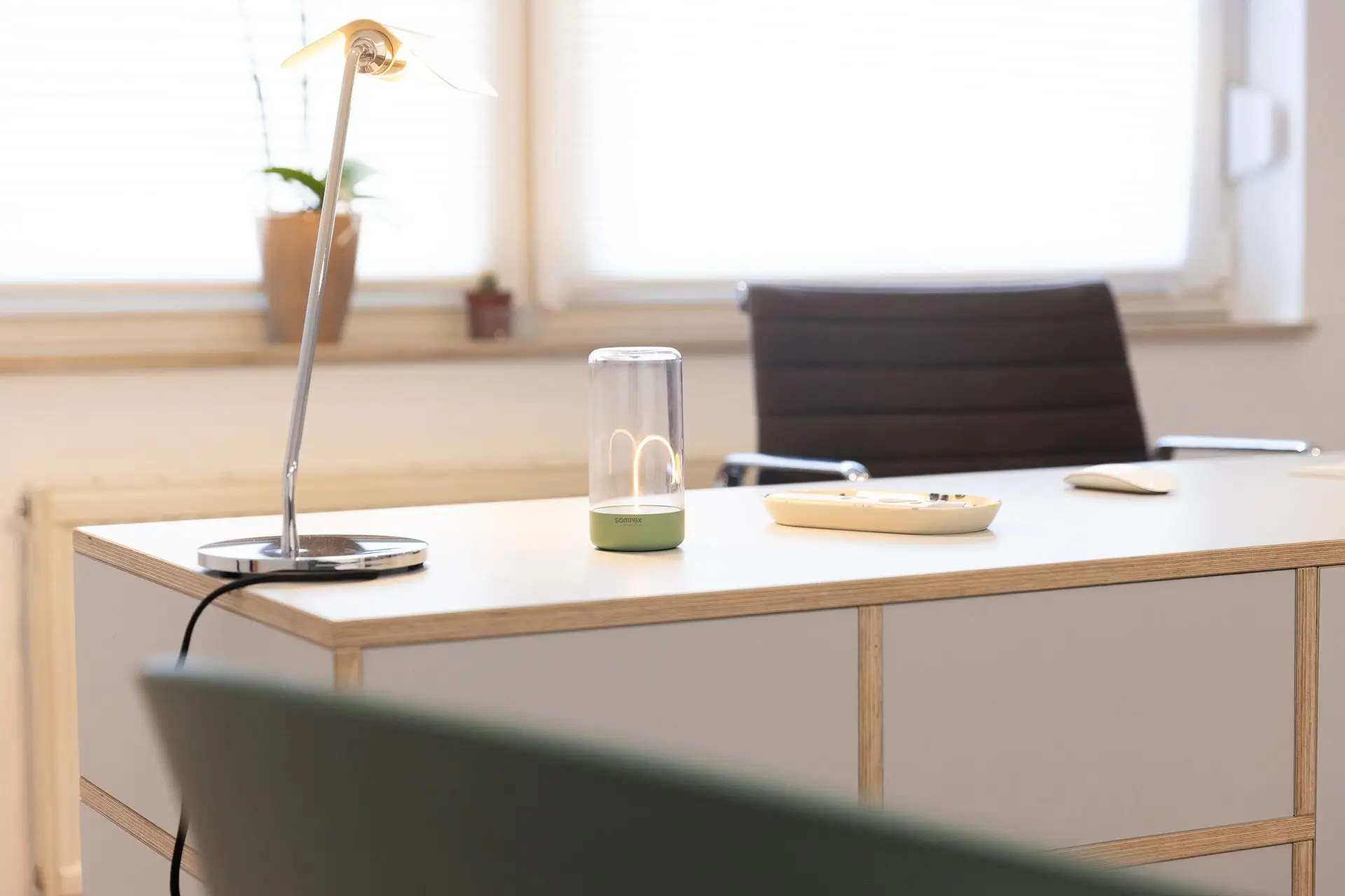 Schreibtisch mit Lampe und Fensterblick in einem Sprechzimmer